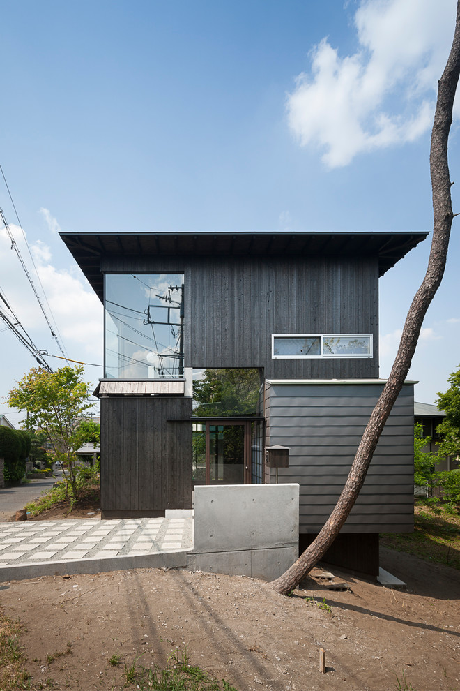 Стильный дизайн: двухэтажный, черный частный загородный дом в стиле ретро - последний тренд