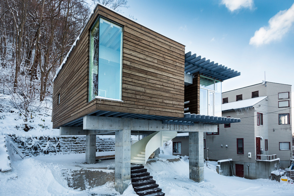 Idee per la facciata di una casa marrone contemporanea con rivestimento in legno