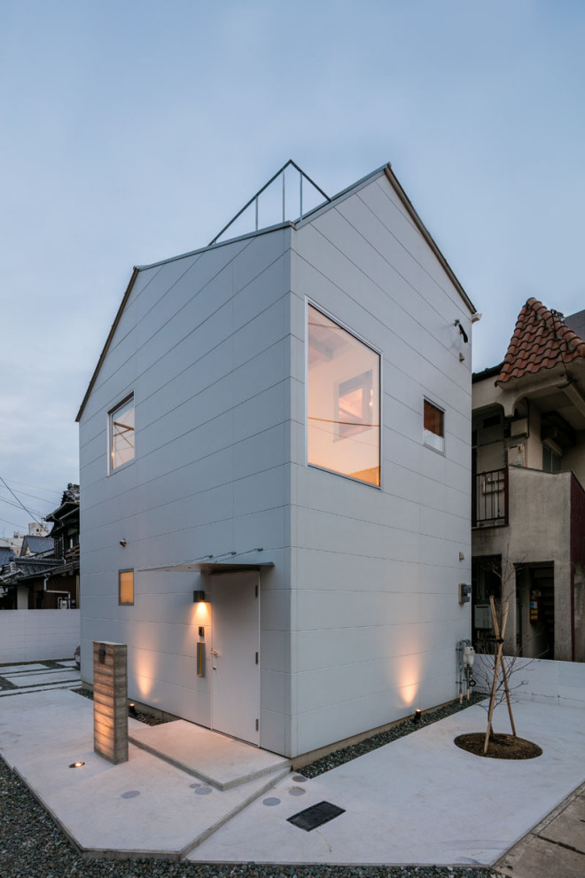 Idée de décoration pour une petite façade de maison blanche minimaliste à un étage avec un revêtement mixte, un toit à deux pans et un toit en métal.