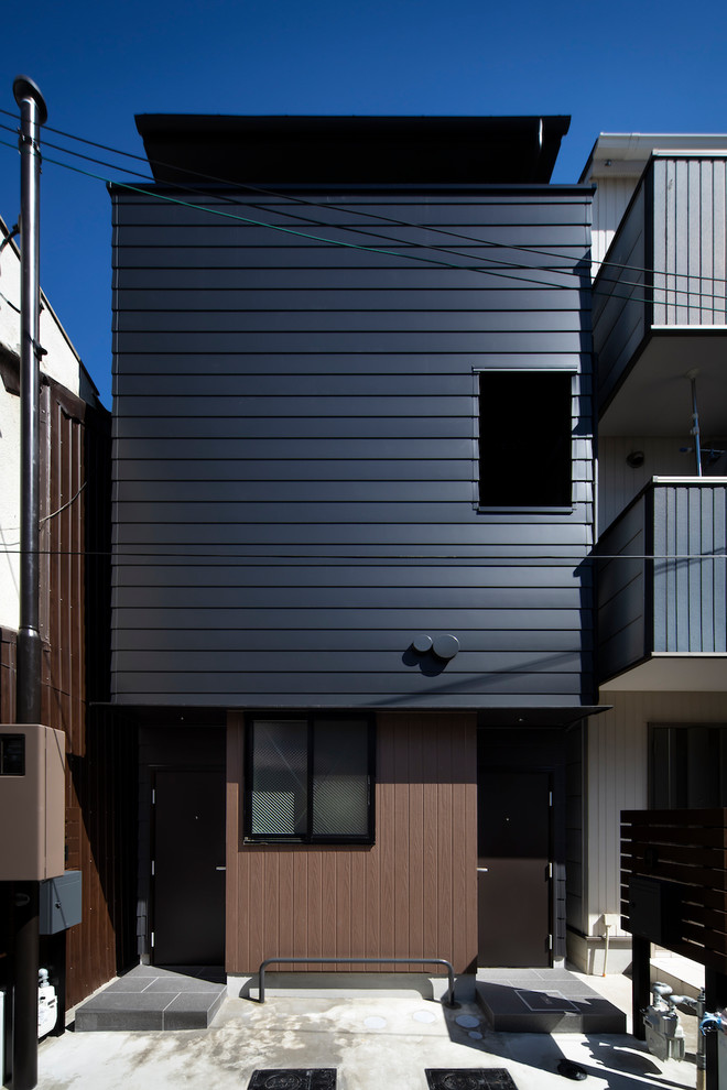 Kleines, Dreistöckiges Modernes Wohnung mit Metallfassade, schwarzer Fassadenfarbe, Pultdach und Blechdach in Osaka