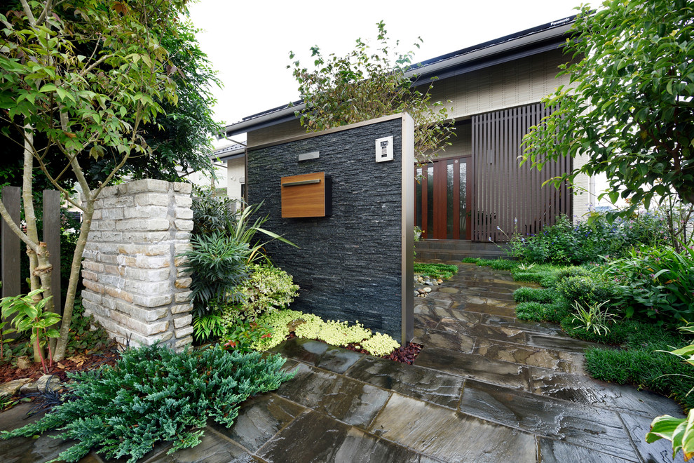 На фото: бежевый частный загородный дом в японском стиле в восточном стиле с