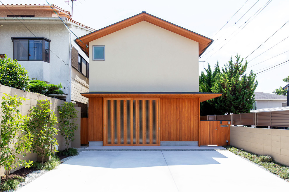 Zweistöckiges Asiatisches Haus mit weißer Fassadenfarbe und Satteldach in Kyoto