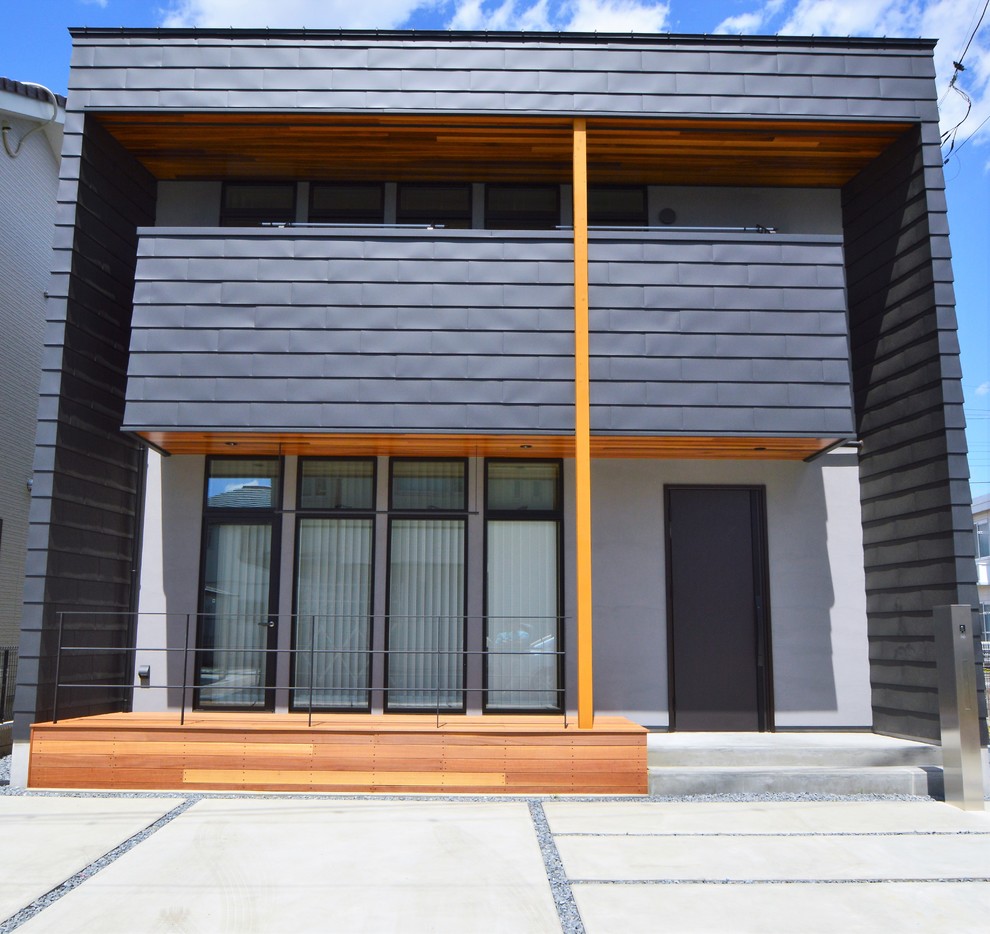 Idées déco pour une façade de maison métallique et noire rétro de taille moyenne et à un étage avec un toit en appentis et un toit en métal.