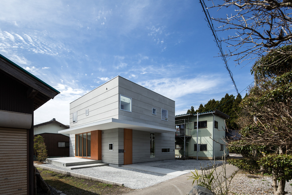 Ejemplo de fachada gris minimalista de tamaño medio de dos plantas con tejado plano