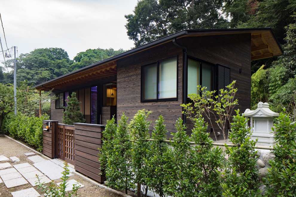 Einstöckige Asiatische Holzfassade Haus mit brauner Fassadenfarbe, Satteldach und Blechdach in Sonstige