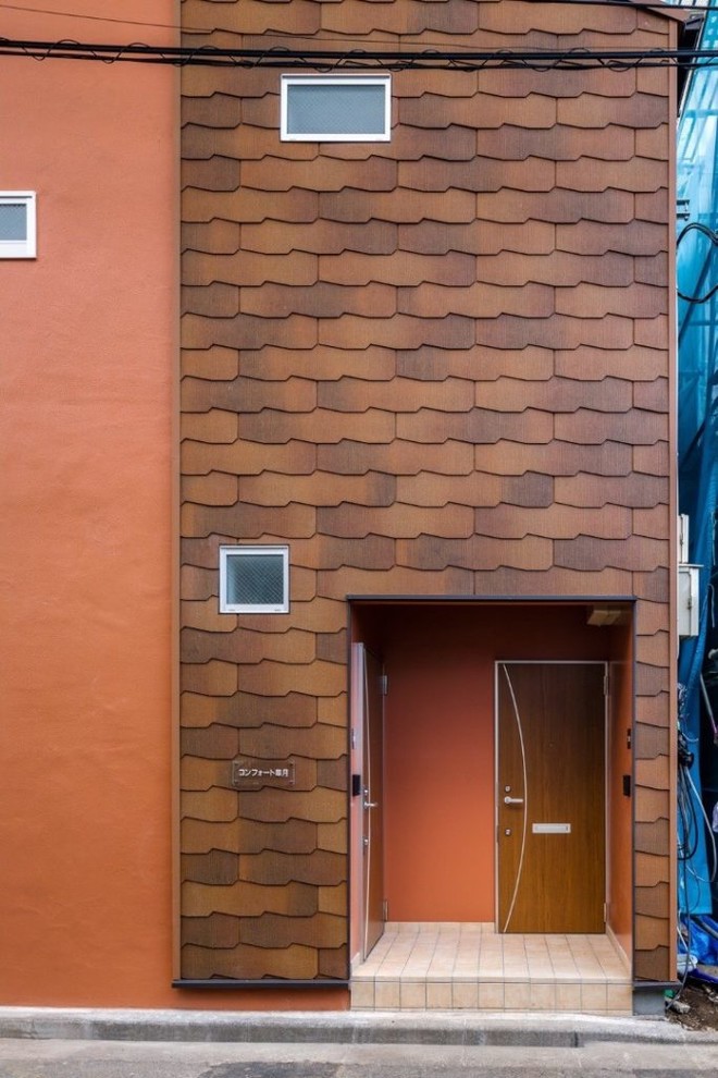 Источник вдохновения для домашнего уюта: двухэтажный, красный многоквартирный дом среднего размера в скандинавском стиле с облицовкой из цементной штукатурки, двускатной крышей и крышей из смешанных материалов