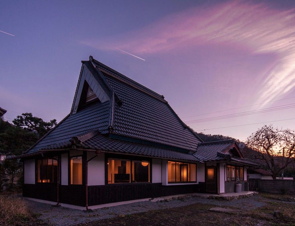 На фото: белый дом в японском стиле в восточном стиле с двускатной крышей с