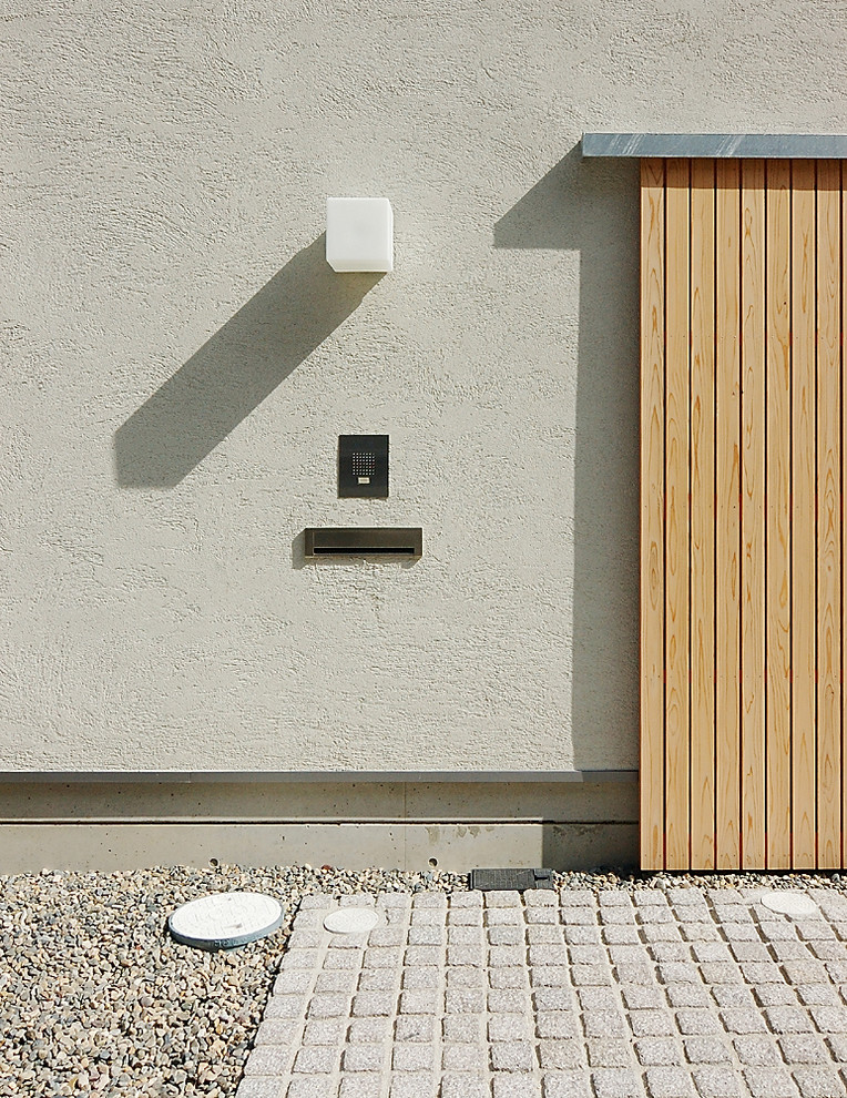 Modelo de fachada de casa blanca minimalista de tamaño medio de dos plantas con revestimiento de piedra, tejado de un solo tendido y tejado de metal