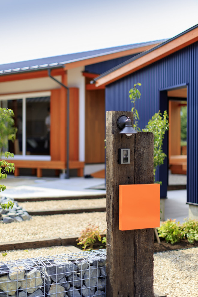 Ejemplo de fachada de casa azul minimalista pequeña de una planta con revestimiento de estuco, tejado de un solo tendido y tejado de metal