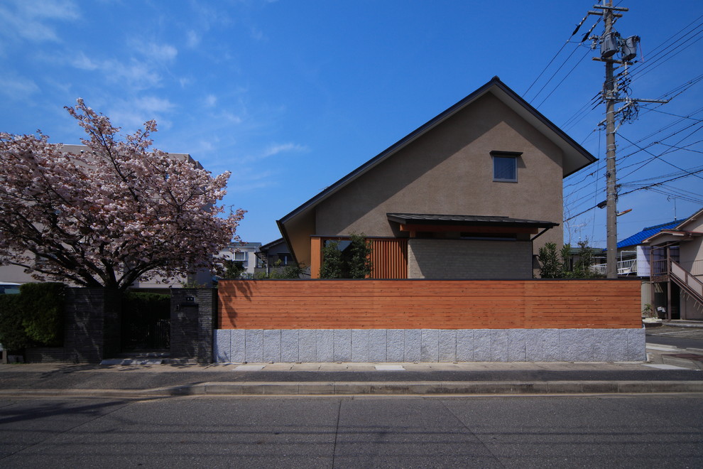 Imagen de fachada de casa marrón asiática de dos plantas con tejado a dos aguas y tejado de metal