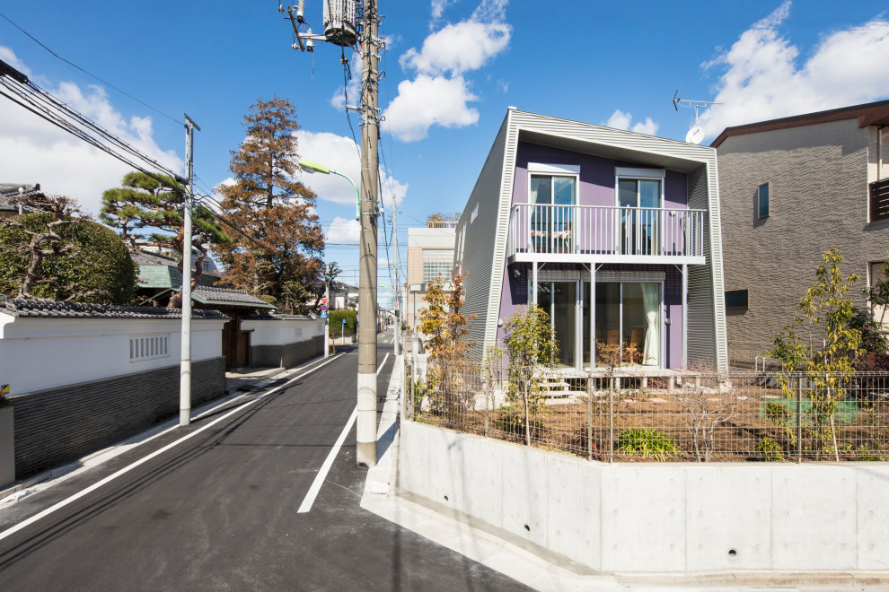 Стильный дизайн: двухэтажный, фиолетовый частный загородный дом среднего размера в стиле модернизм с облицовкой из металла, односкатной крышей и металлической крышей - последний тренд