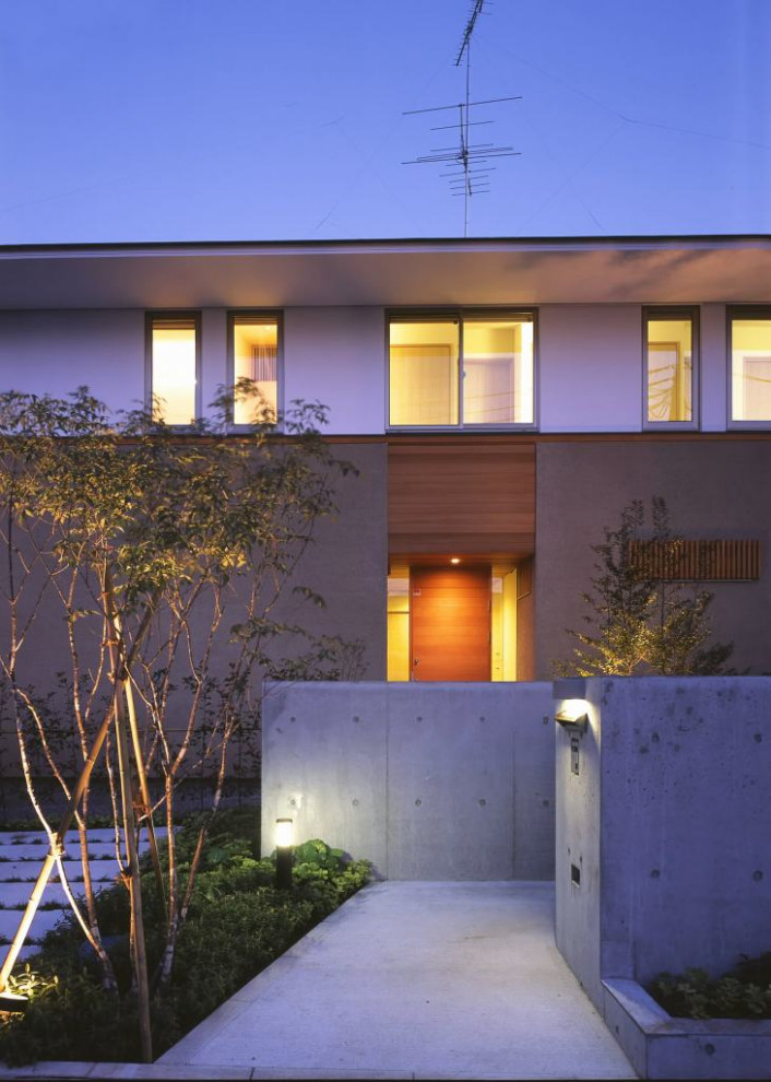 Inspiration pour une façade de maison beige minimaliste en stuc de taille moyenne et à un étage avec un toit à quatre pans et un toit en métal.