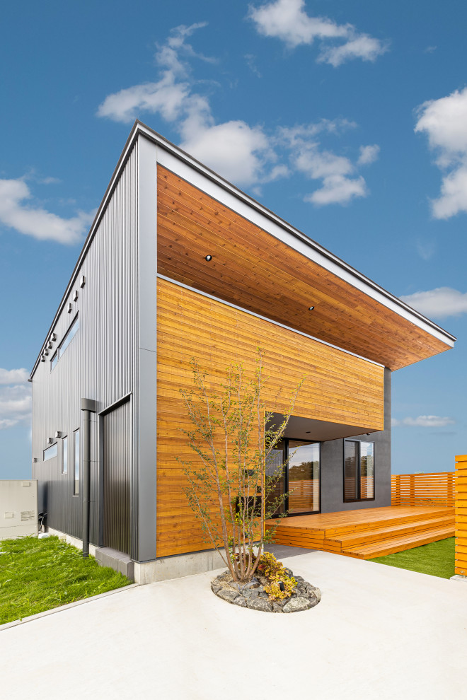 Mittelgroßes, Zweistöckiges Modernes Einfamilienhaus mit Mix-Fassade, schwarzer Fassadenfarbe, Pultdach und Blechdach in Sonstige