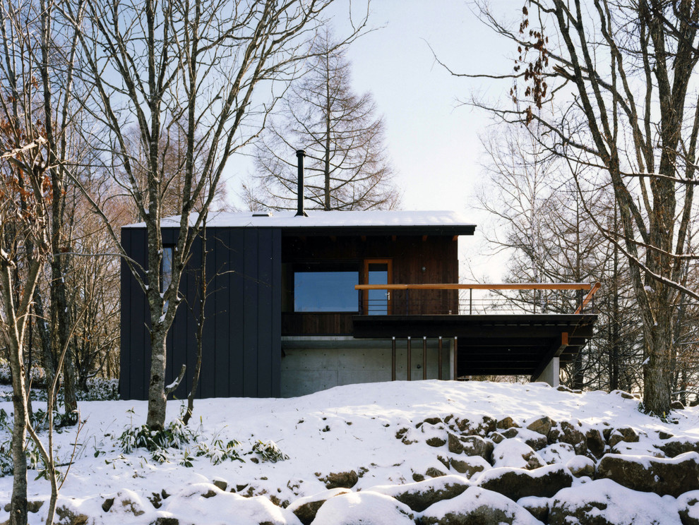 Exemple d'une façade de maison noire montagne en bois de taille moyenne et à un étage.