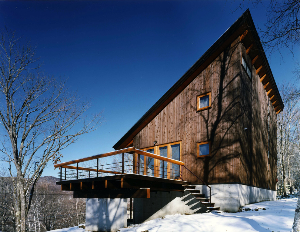 Modelo de fachada marrón de estilo de casa de campo de dos plantas con revestimiento de madera y tejado de un solo tendido