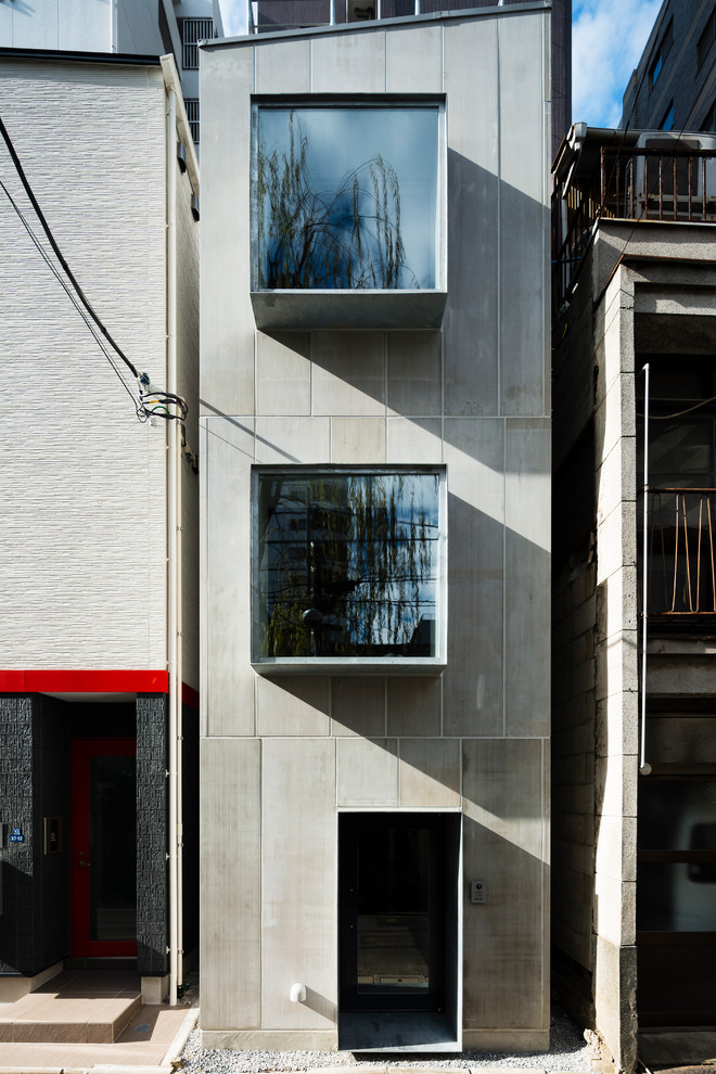 Immagine della facciata di una casa piccola grigia moderna a tre piani
