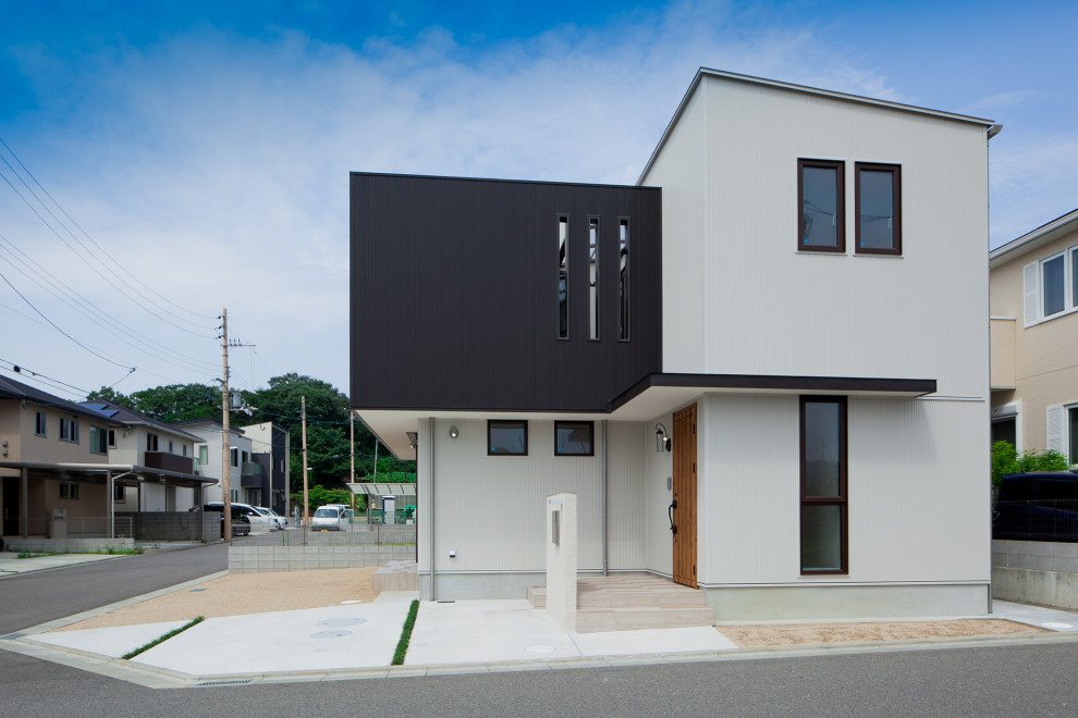 Foto på ett minimalistiskt vitt hus, med två våningar