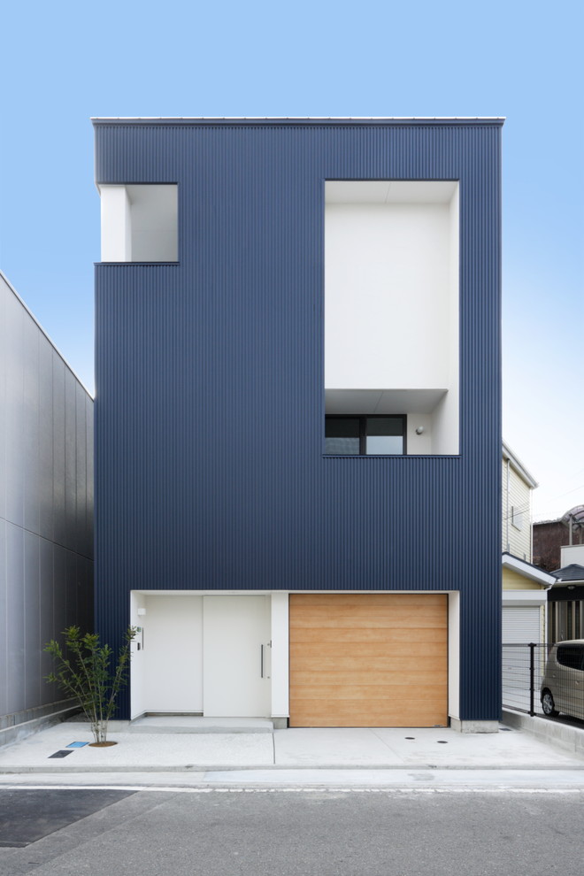 Пример оригинального дизайна: трехэтажный, синий частный загородный дом в современном стиле с плоской крышей