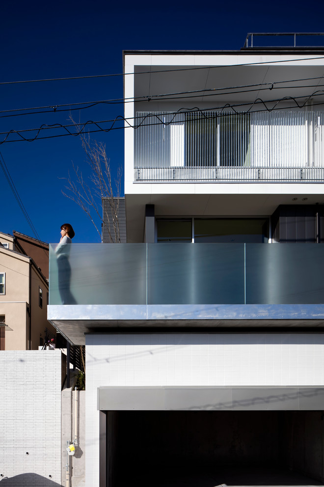 Ejemplo de fachada blanca minimalista de tamaño medio de dos plantas con tejado a dos aguas