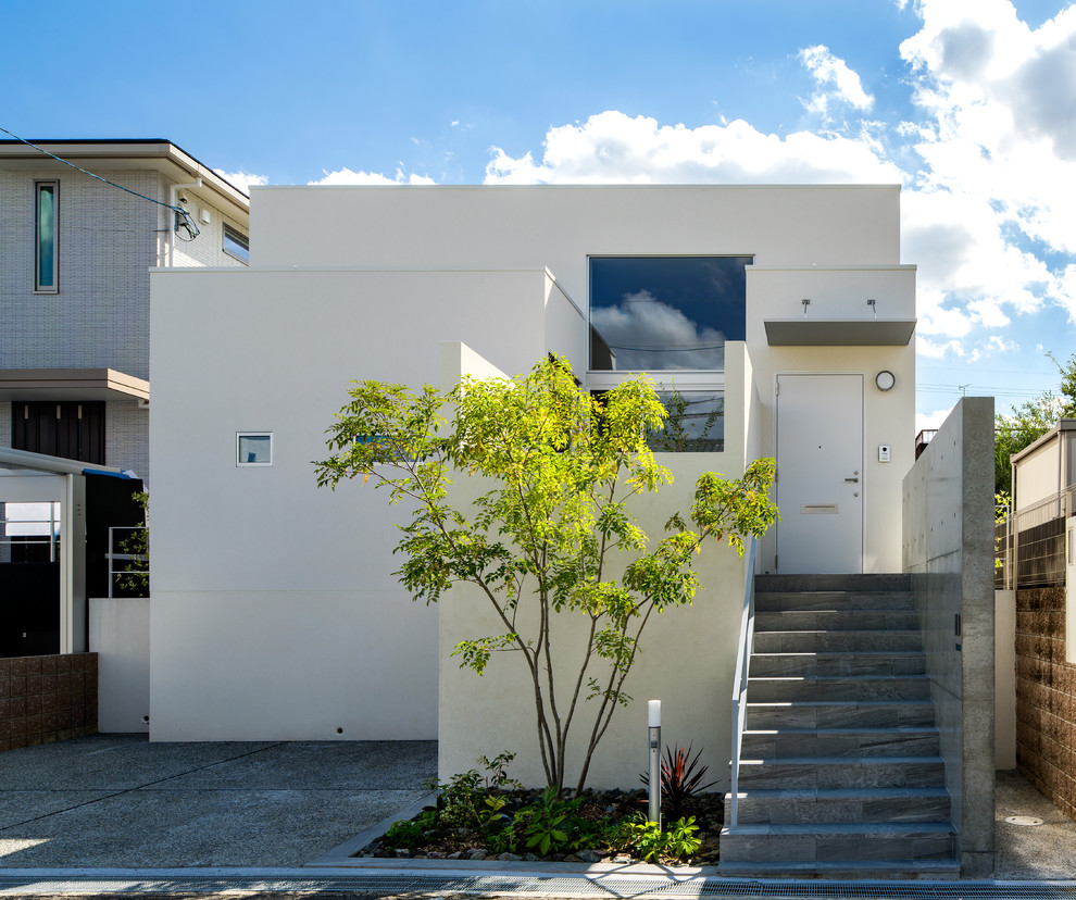 Einstöckiges Modernes Einfamilienhaus mit weißer Fassadenfarbe und Flachdach in Osaka