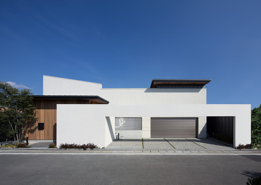 Réalisation d'une façade de maison blanche design avec un toit en appentis, un toit en métal et un toit noir.