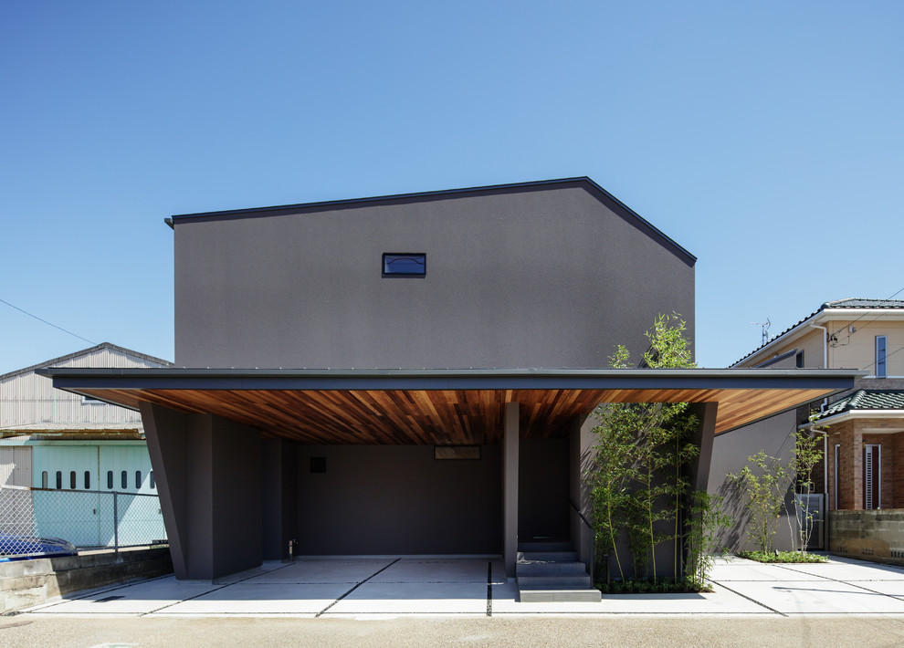 На фото: черный дом в современном стиле с двускатной крышей с