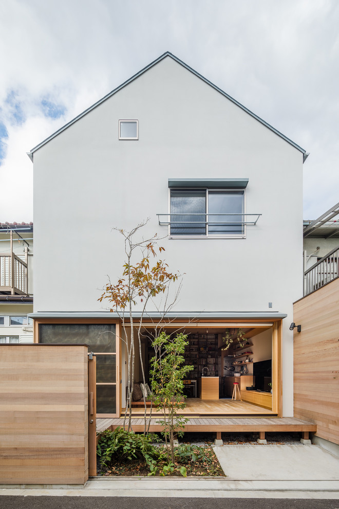 Photo of a white modern house exterior in Tokyo with a pitched roof.