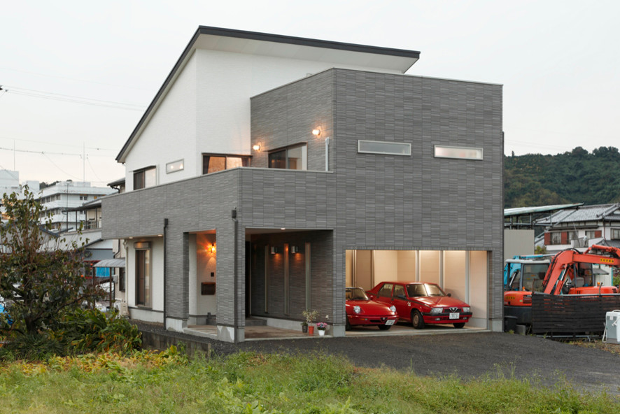 Стильный дизайн: большой, двухэтажный, разноцветный частный загородный дом в стиле модернизм с комбинированной облицовкой и односкатной крышей - последний тренд