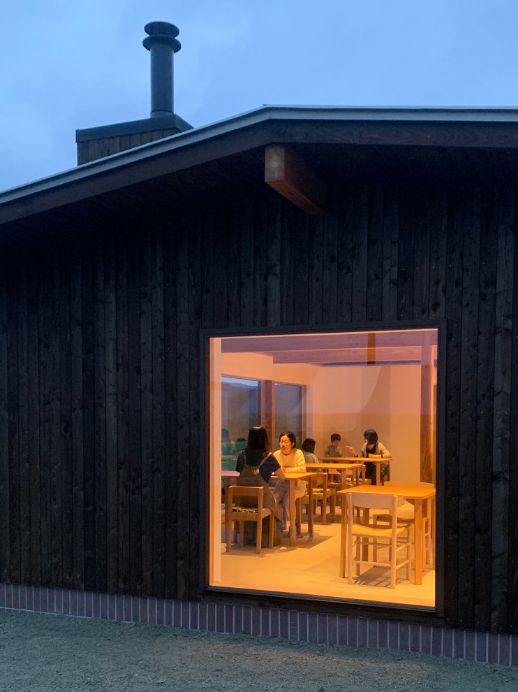 This is an example of a small and black scandinavian bungalow tiny house in Other with wood cladding, a pitched roof and a metal roof.