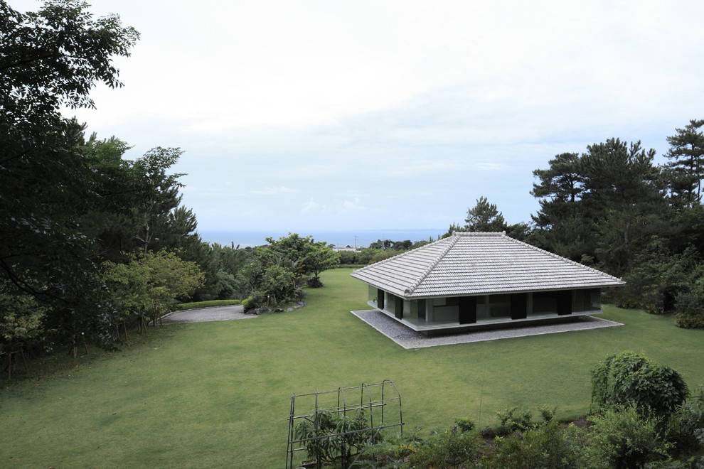Aménagement d'une petite façade de maison asiatique avec un toit à quatre pans.