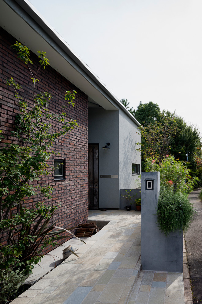 Uriges Haus mit Backsteinfassade und grauer Fassadenfarbe in Sonstige