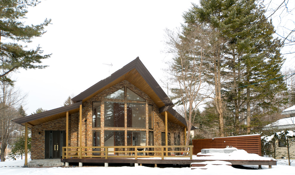 Réalisation d'une façade de maison marron design en brique avec un toit à deux pans.