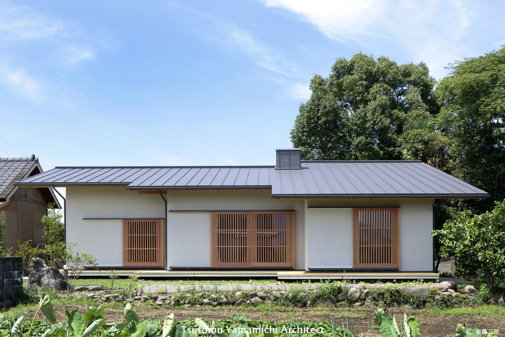 Foto de fachada blanca de estilo zen de una planta con tejado a dos aguas