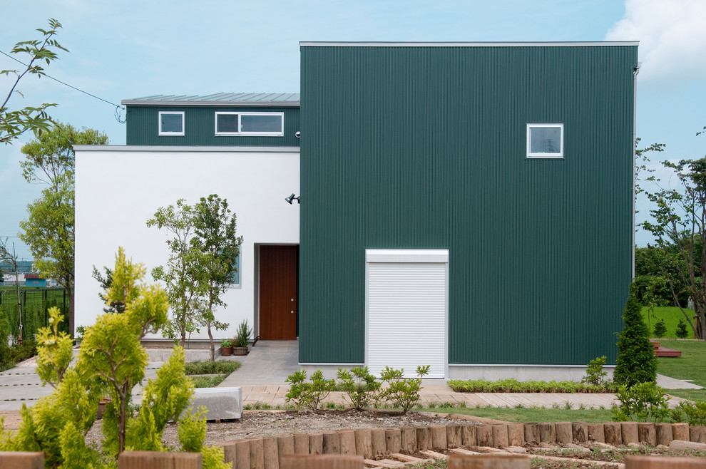 This is an example of a green contemporary detached house in Other with mixed cladding and a flat roof.