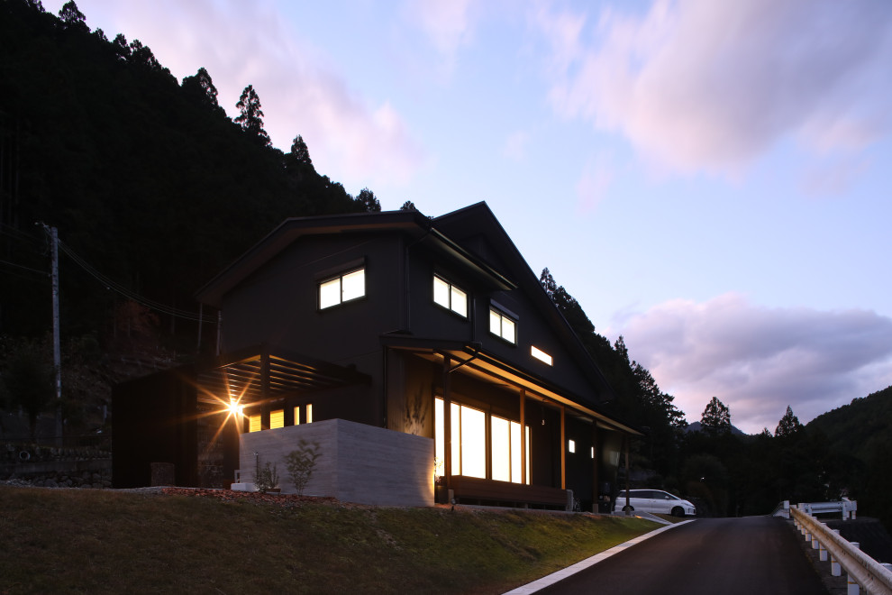 Imagen de fachada de casa negra minimalista de tamaño medio de dos plantas con revestimientos combinados, tejado de un solo tendido y tejado de varios materiales