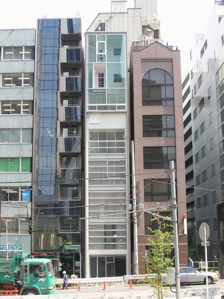 Inspiration för mellanstora moderna bruna lägenheter, med tre eller fler plan, glasfasad och platt tak