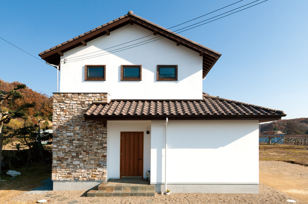 Источник вдохновения для домашнего уюта: белый частный загородный дом в восточном стиле с облицовкой из цементной штукатурки, двускатной крышей и черепичной крышей