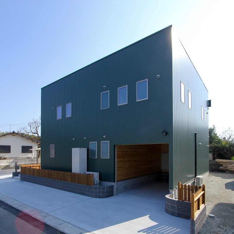 Ejemplo de fachada de casa verde urbana grande de dos plantas con revestimiento de metal, tejado plano y tejado de metal