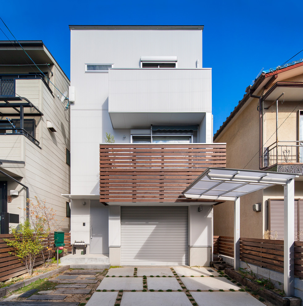 Стильный дизайн: трехэтажный, серый дом в современном стиле с облицовкой из металла и плоской крышей - последний тренд