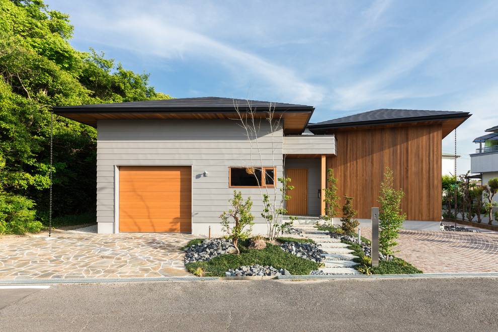 Idées déco pour une façade de maison multicolore asiatique de plain-pied avec un revêtement mixte et un toit à quatre pans.