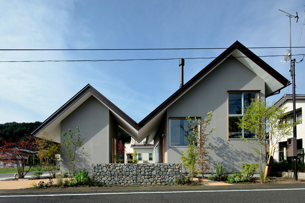 Esempio della facciata di una casa grigia contemporanea con tetto a capanna