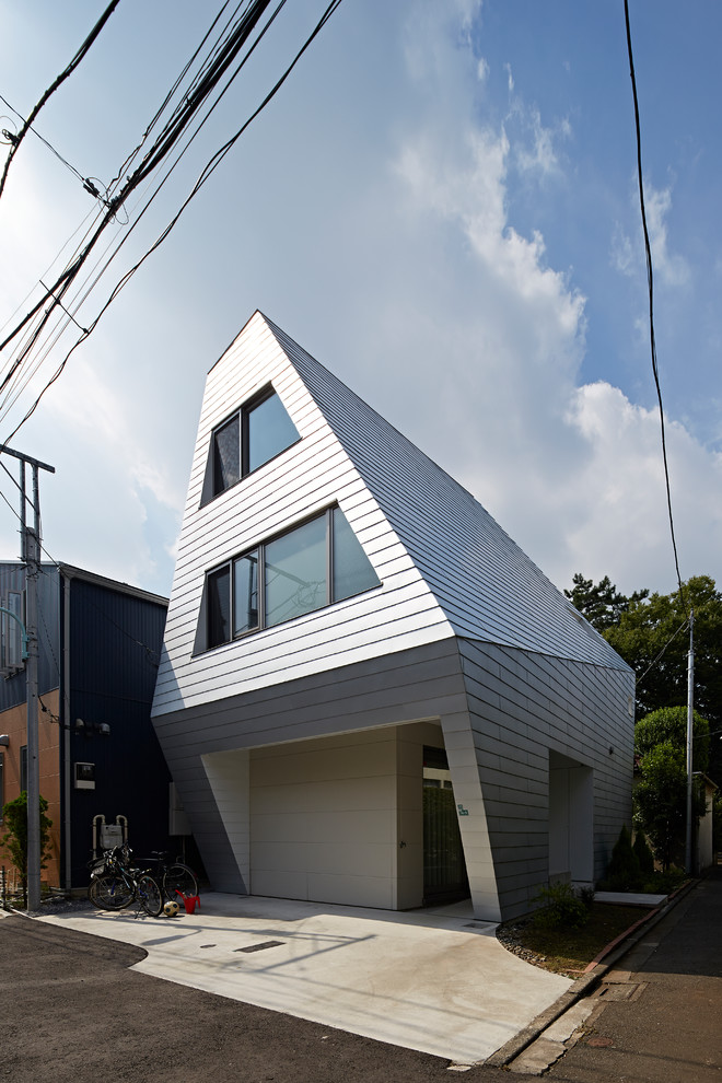 Inspiration pour une façade de maison minimaliste à niveaux décalés avec un toit en métal.
