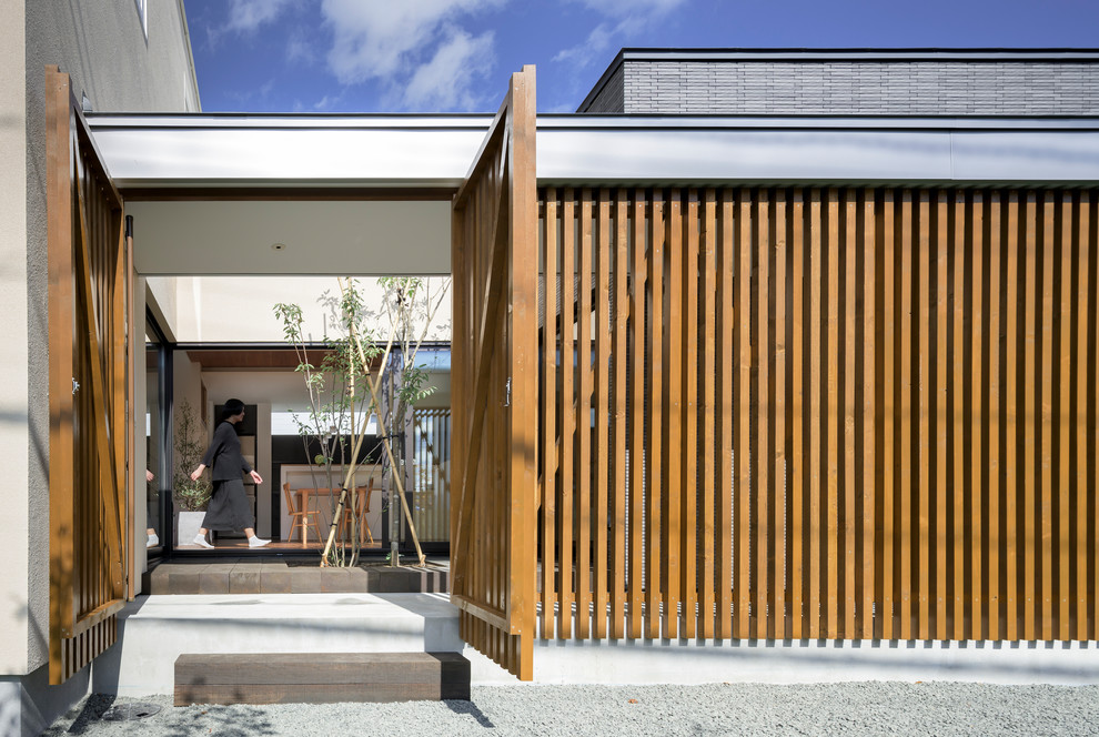 Réalisation d'une façade de maison blanche minimaliste en stuc de taille moyenne et à un étage avec un toit plat et un toit en métal.