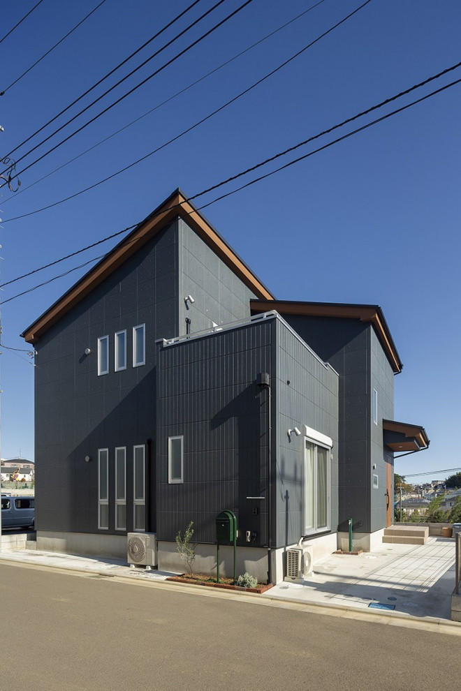 Idées déco pour une façade de maison noire industrielle de taille moyenne et à un étage.