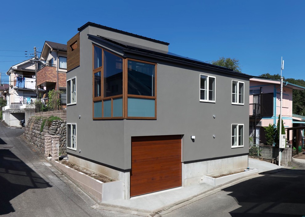 Aménagement d'une façade de maison grise contemporaine à deux étages et plus avec un toit en appentis.