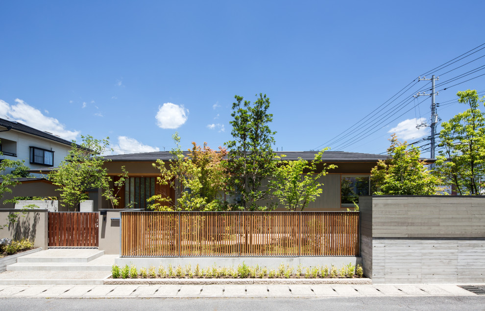 Einstöckiges Asiatisches Einfamilienhaus mit grauer Fassadenfarbe, Blechdach, Walmdach und schwarzem Dach in Sonstige