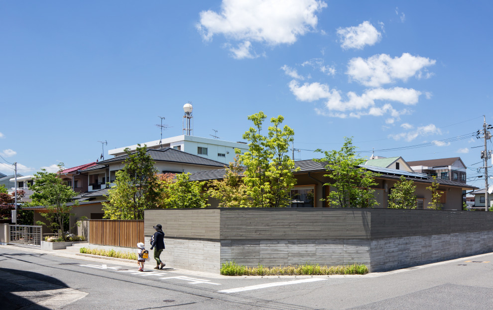 Идея дизайна: одноэтажный, серый частный загородный дом в восточном стиле с двускатной крышей и металлической крышей