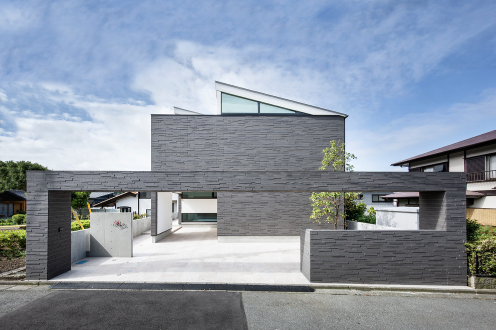 Свежая идея для дизайна: двухэтажный, серый частный загородный дом среднего размера в стиле модернизм с облицовкой из камня, односкатной крышей и металлической крышей - отличное фото интерьера