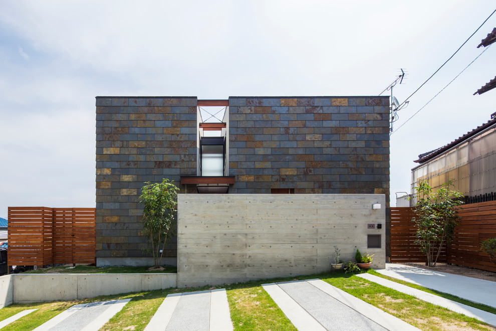 Свежая идея для дизайна: двухэтажный, разноцветный дом в современном стиле с облицовкой из камня и плоской крышей - отличное фото интерьера