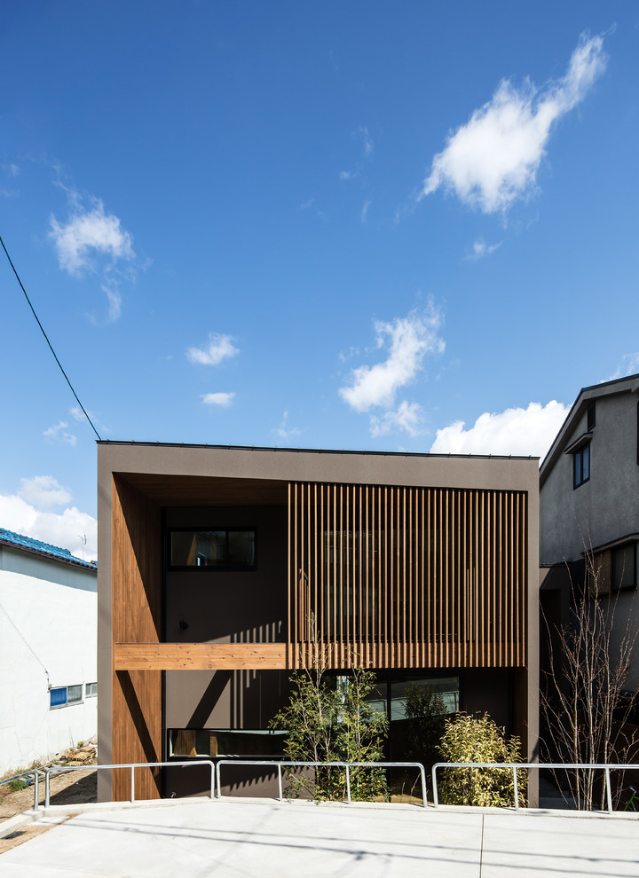 Photo of a brown modern two floor detached house in Osaka with a flat roof.